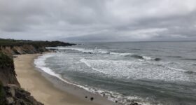 Pacific ocean waves against rocky beach/cliffs